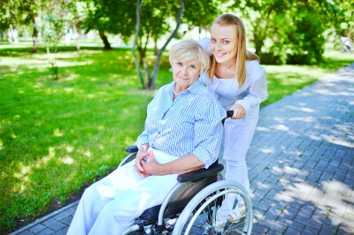 caregiver and senior in a wheelchair smiling